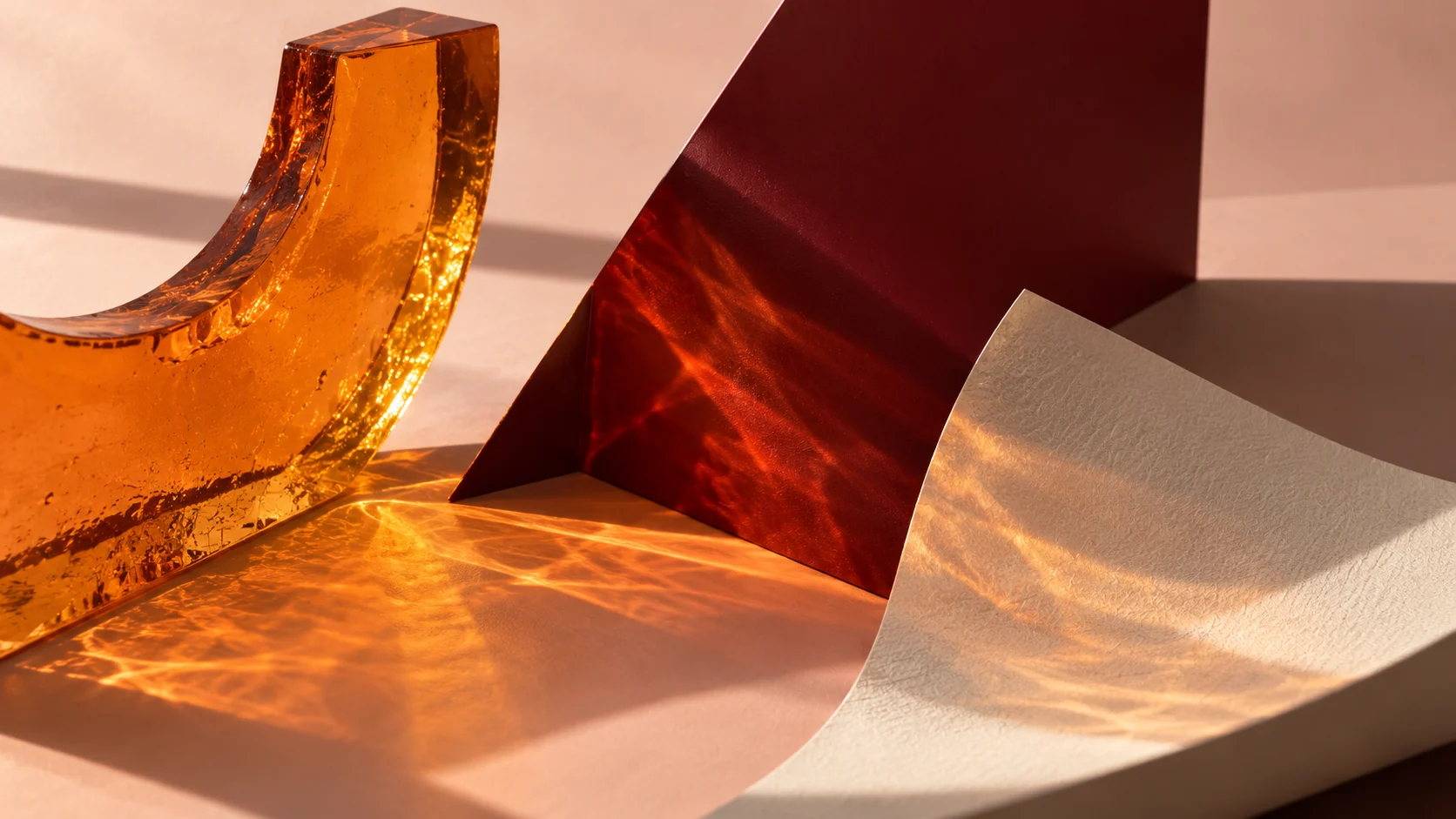 Conceptual brand image: amber glass, folded oxblood card and curved paper catching warm light and reflections.
